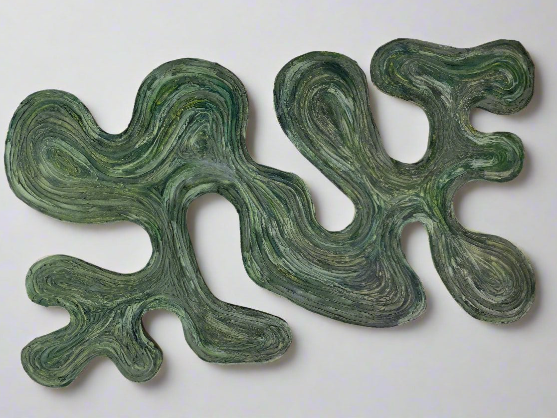 A laser cutting that is covered in texture that is painted turquoise, green, and and lime green . This artwork is also a laser cutting